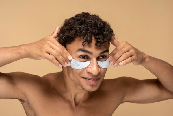 A man applying under eye patches